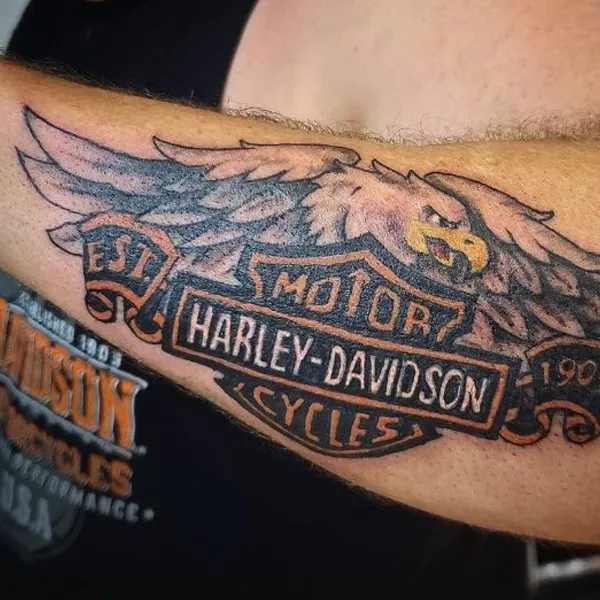 Close-up of a man's arm with a Harley-Davidson tattoo