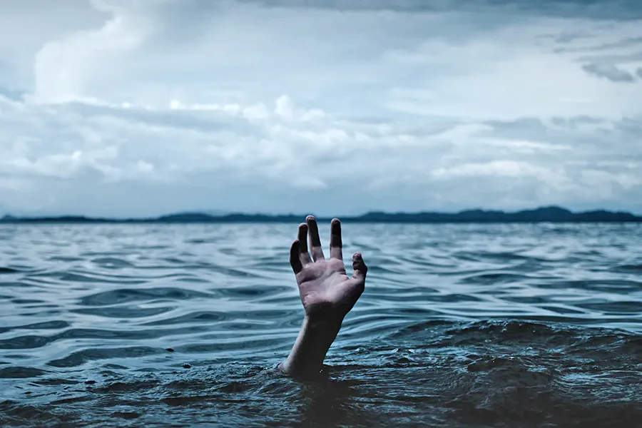 hand raising out of the deep waters reaching for help